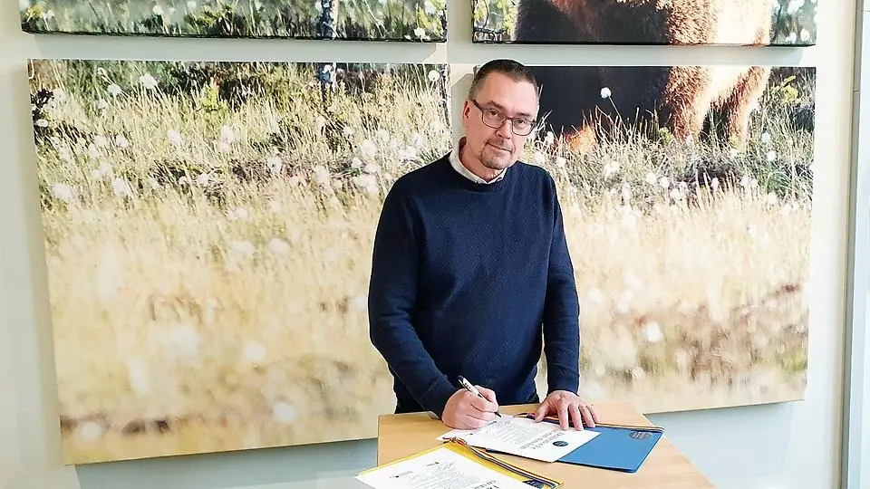 Kommunstyrelsens ordförande Mikael Thalin (C) skriver under deklaration för en stark demokrati. Foto.