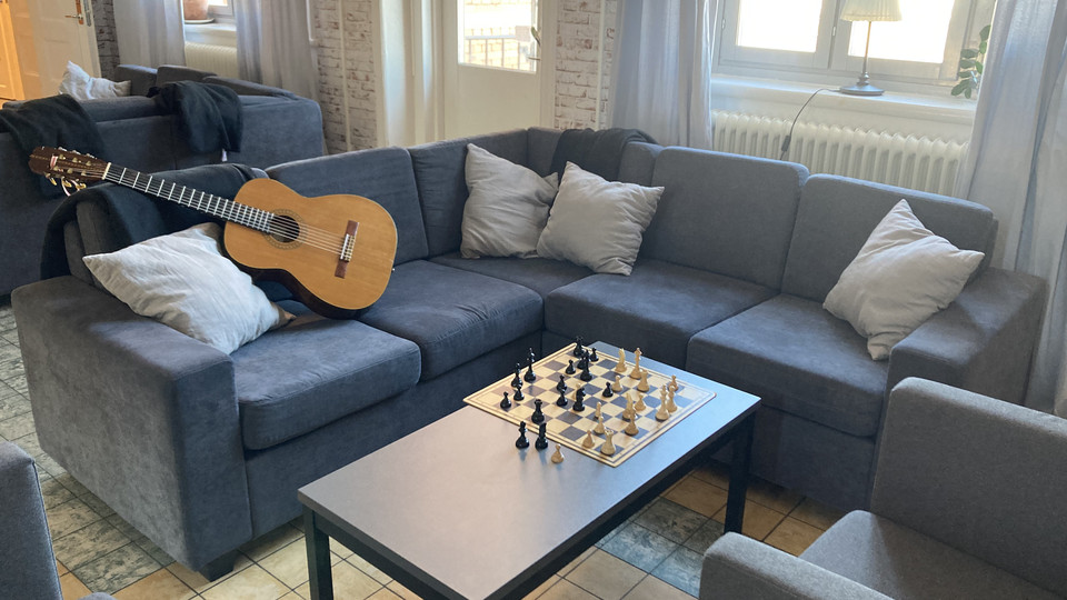 Soffhörna på Ungdomens hus. Det ligger en gitarr i soffan och det står ett schackspel på bordet. Foto.