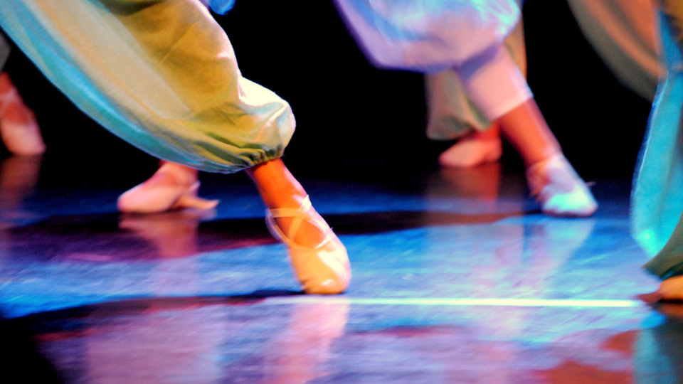Fötter i balettskor på dansuppvisning.