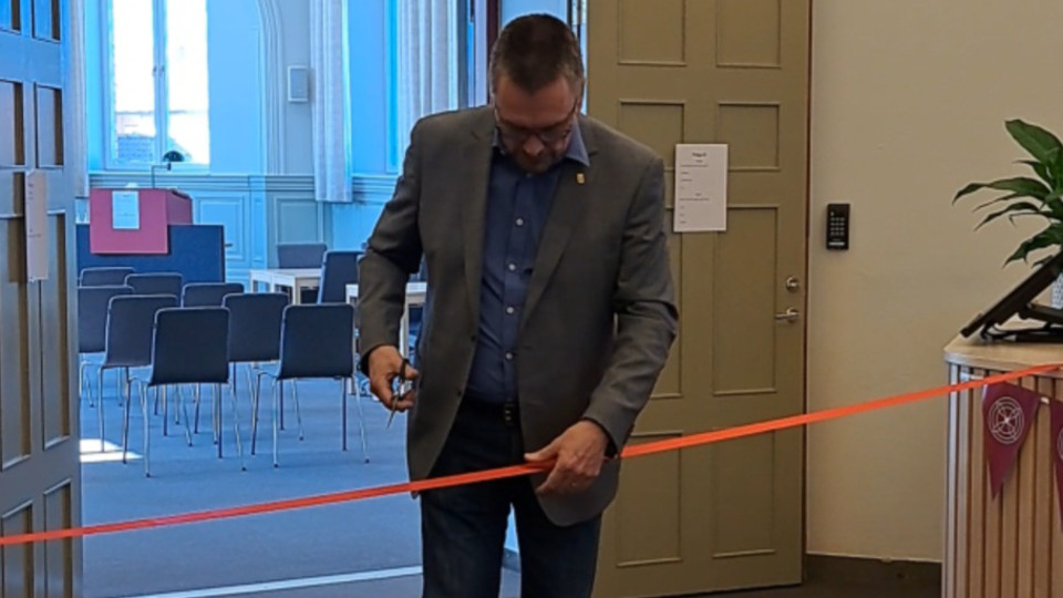 Kommunstyrelsens ordförande Mikael Thalin (C) klipper det röda bandet och inviger renoveringen av kommunens kontaktcenter. Foto.
