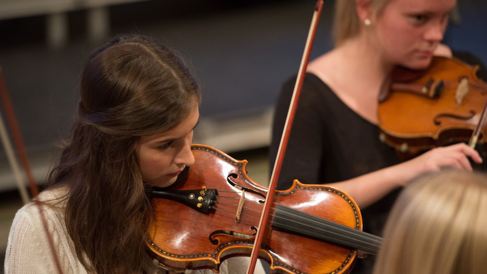 Två unga elever spelar fiol.