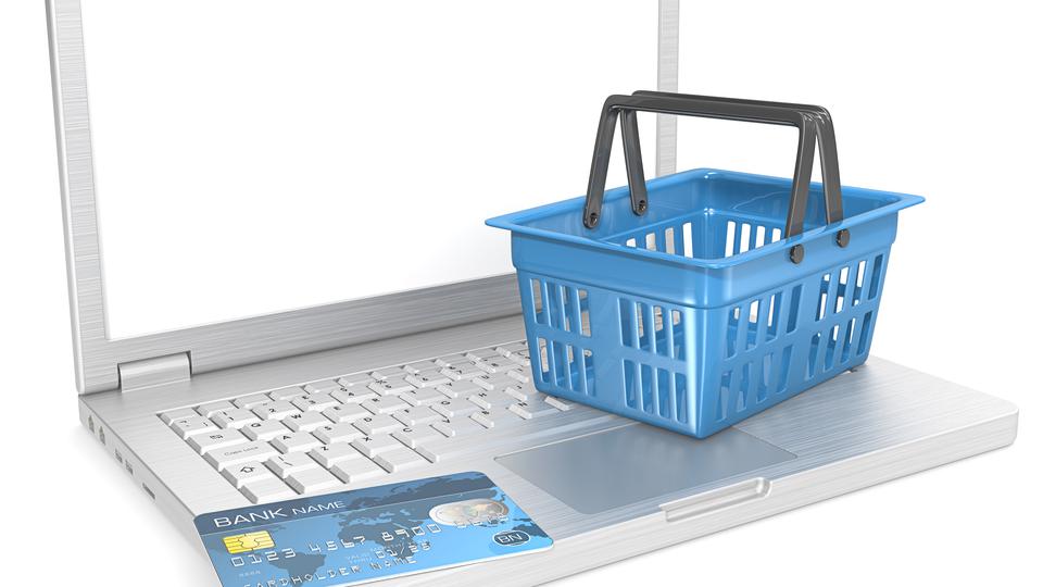 En 3D-illustration av en dator, bankkort och en kundkorg. Detta för att symbolisera e-handel. 