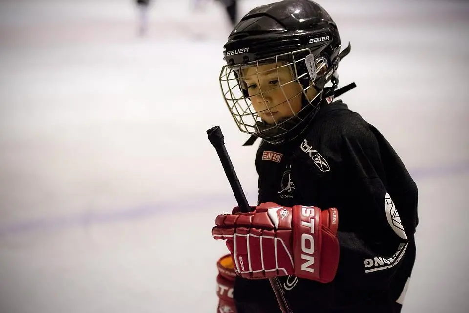 En väldigt ung hockeyspelare i full utrustning på isen. Foto.