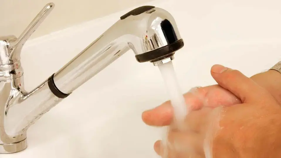 Händer som tvättas under en kran med rinnande vatten